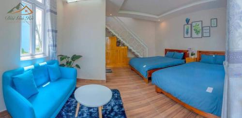 - un salon avec des lits bleus et un escalier dans l'établissement Moonlight Homestay, à Đà Lạt