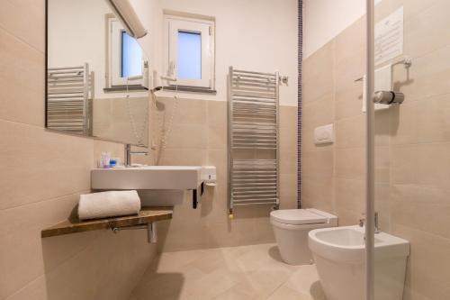 a bathroom with a sink and a toilet and a mirror at Hotel Giosue' a mare Sorrento in Meta