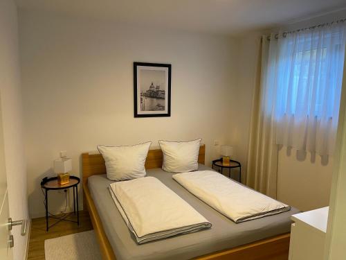 ein Schlafzimmer mit einem Bett mit zwei Kissen darauf in der Unterkunft Harmonie am Bodensee in Friedrichshafen
