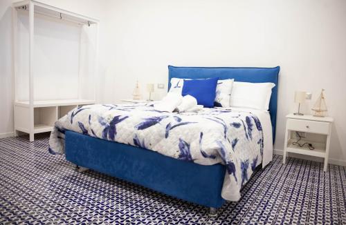 ein blaues Bett mit einer blauen und weißen Bettdecke in der Unterkunft White Blu House - Massa Lubrense Sorrento in Massa Lubrense