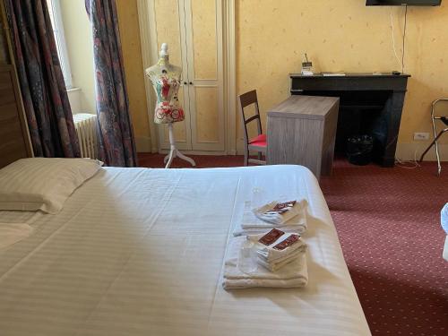 a hotel room with a bed with a towel on it at Hôtel du Commerce in Semur-en-Auxois