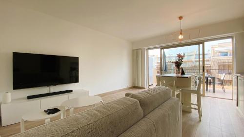 a living room with a couch and a flat screen tv at T2 Bricka La Terrasse de la plage, Moderne, équipé, Lumineux in Antibes