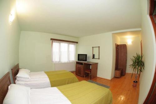 una camera da letto con due letti e una scrivania con televisione di Casa dintre Vii a Jidvei