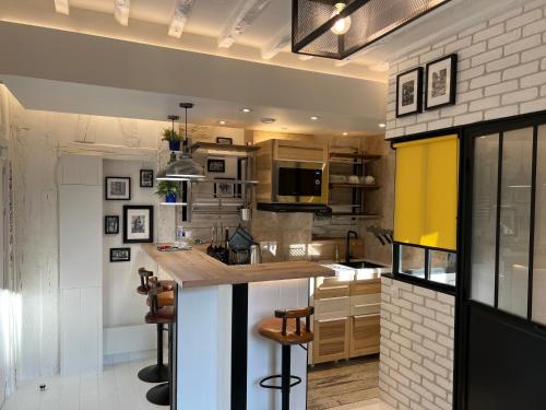 - une cuisine avec un comptoir et quelques chaises dans l'établissement Au Passage des Marais - City Centre, à Paris