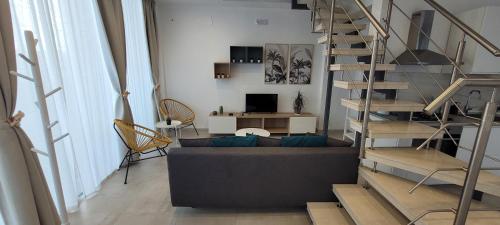 ein Wohnzimmer mit einem Sofa und einer Wendeltreppe in der Unterkunft Eos Sea View Apartments in Syrakus