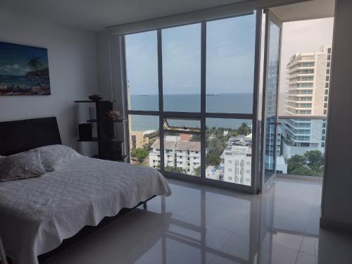 a bedroom with a bed and a large window at APARTAMENTO BELLO HORIZONTE in Santa Marta