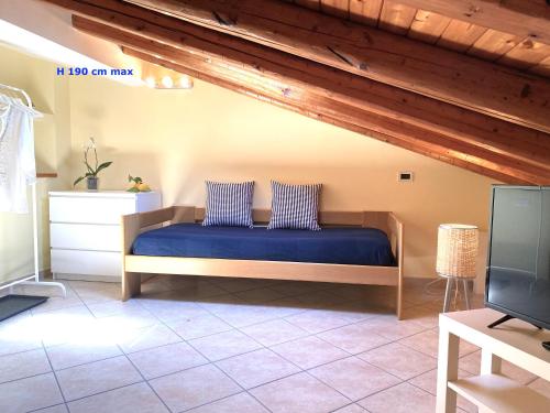 a bedroom with a bed with blue sheets and wooden ceilings at Torre Archirafi Vacanze in Riposto