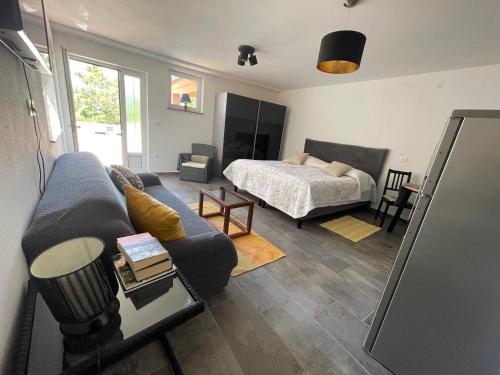 a living room with a couch and a bed at Apartments Villa Antonia in Jadranovo