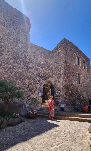 a woman standing in front of a building at La villetta TRE PALME in Valledoria
