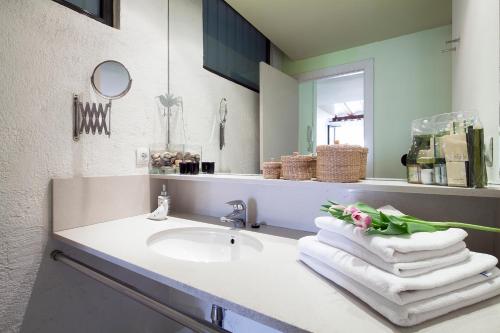 y baño con lavabo, toallas y espejo. en Inside Barcelona Apartments Esparteria, en Barcelona