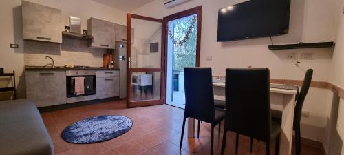 a kitchen with a table and chairs and a television at La villetta TRE PALME in Valledoria