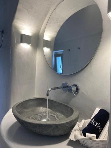 a bathroom sink with a large stone vessel sink at Lamar Cave house in Emporio Santorini