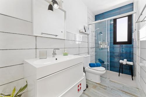 a white bathroom with a sink and a toilet at Holiday in Lanzarote! in Tías