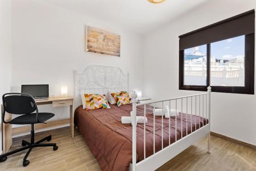 1 dormitorio con 1 cama y escritorio con ordenador en Holiday in Lanzarote!, en Tías