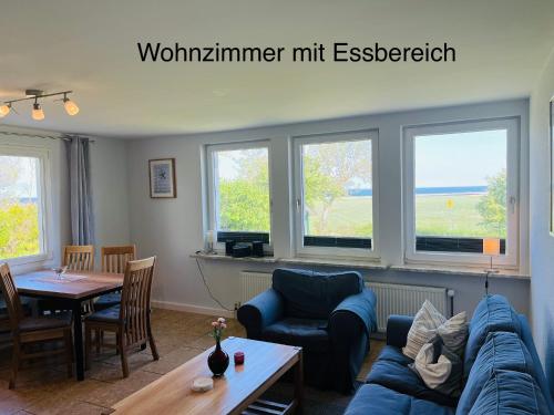 a living room with a blue couch and a table at Ferienwohnung Ostseeblick in Kägsdorf