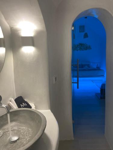 a bathroom with a sink and a blue hallway at Lamar Cave house in Emporio Santorini
