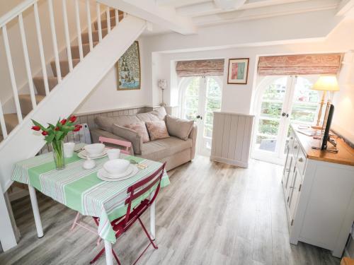 a living room with a table and a couch at 1 Manor Cottage in Stow on the Wold