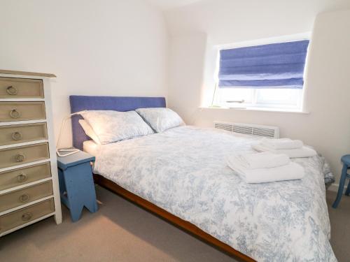 1 dormitorio con 1 cama, vestidor y ventana en 1 Manor Cottage en Stow on the Wold