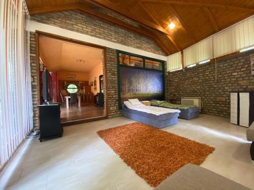 sala de estar con sofá y pared de ladrillo en Ambiente, en Kiskunhalas