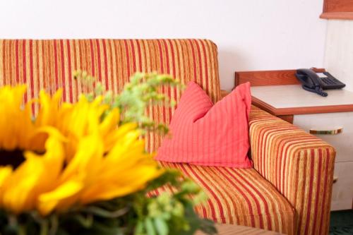 a couch with two pillows on it next to a table at LandKomfort Hotel Elsenmann Garni in Willingen
