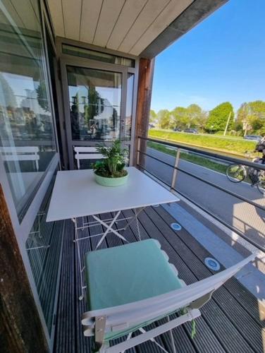 a white table and a chair on a balcony at Maison Noordburg Veurne in Veurne