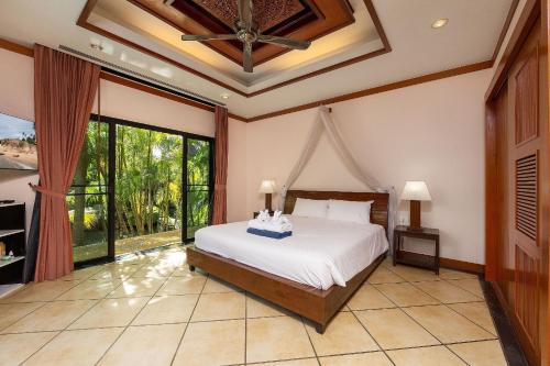 - une chambre avec un lit et une grande fenêtre dans l'établissement Villa Hoata| Luxury 2BR villa in the Baan Bua Estate | Nai Harn beach, à Nai Harn Beach