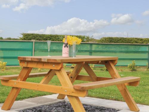 a wooden picnic table with a vase of flowers on it at Primrose in Hull