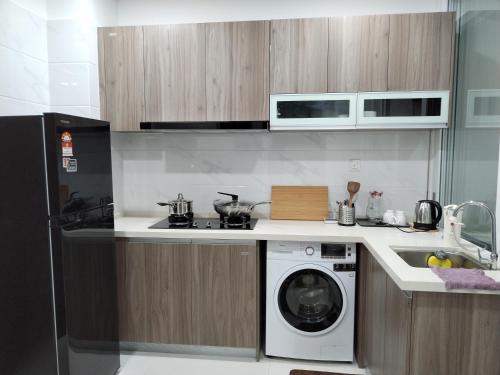een keuken met een wasmachine en een wastafel bij Lovely Sweet Home in Johor Bahru