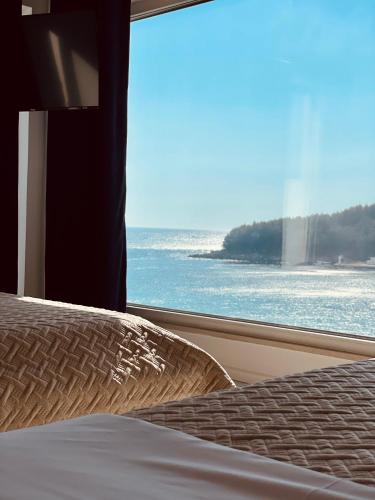 a bedroom with a view of the ocean from a window at Ionian Terrace in Himare