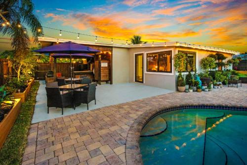 a house with a swimming pool and a patio at Private Heated Pool Oasis Pet-Friendly Retreat Short or long Stays Sleeps 2-8 Ppl in Pompano Beach