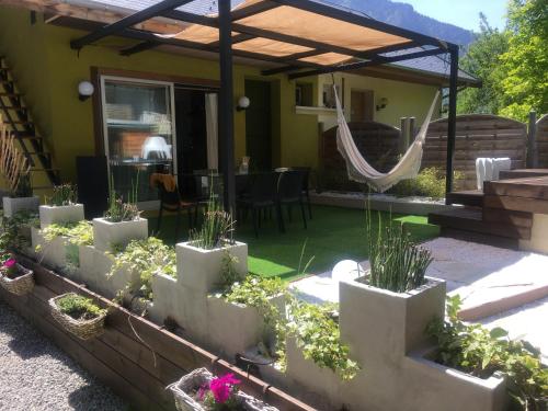 a backyard with a patio with plants and a hammock at Ô Lit' Chi in Hermillon