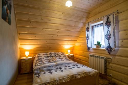 a bedroom with a bed in a log cabin at Apartamenty u Gabi in Poronin