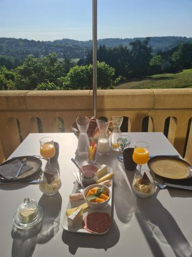 - une table blanche avec de la nourriture et des boissons dans l'établissement La Maison Thimadaise, à Sarlat-la-Canéda