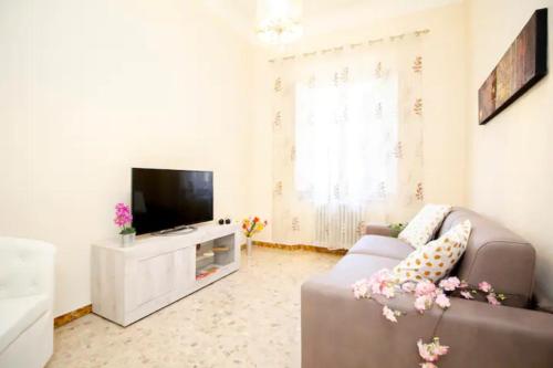 a living room with a couch and a flat screen tv at InnPisaRentals - Santa Maria Flat in Pisa