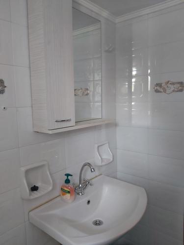 a white bathroom with a sink and a cabinet at Voula Pansion in Kardamili