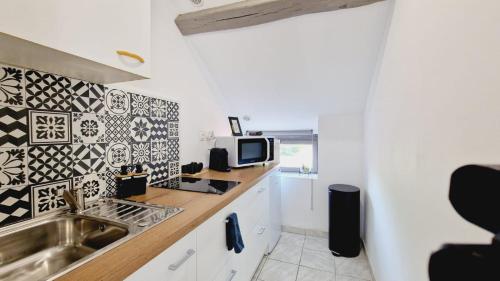 a kitchen with a sink and a microwave at J.Mo Home - Louvroil - Calme - Idéal couple - Déplacement PRO in Louvroil