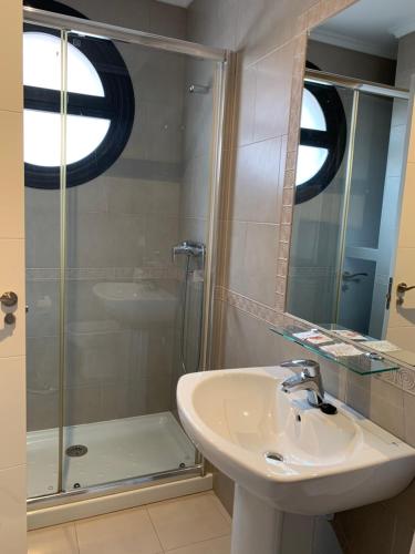 a bathroom with a sink and a shower at Apartamentos Verdemar (VUT) in Llanes