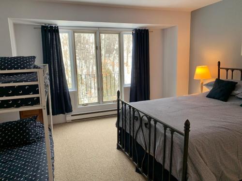 ein Schlafzimmer mit einem Bett und einem großen Fenster in der Unterkunft Condo Club Azur Plage Memphremagog in Magog-Orford