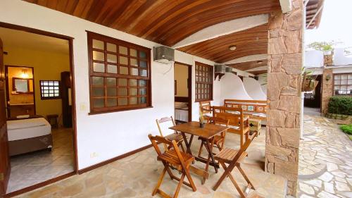 a patio with a wooden table and chairs at HOTELARE Hotel Brunello in Paraty