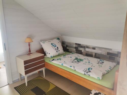 Habitación pequeña con cama y mesita de noche en GästeZimmer im Altbau Dachgeschoss mit kleinem Bad WLAN, TV und Parkplatz en Lachen