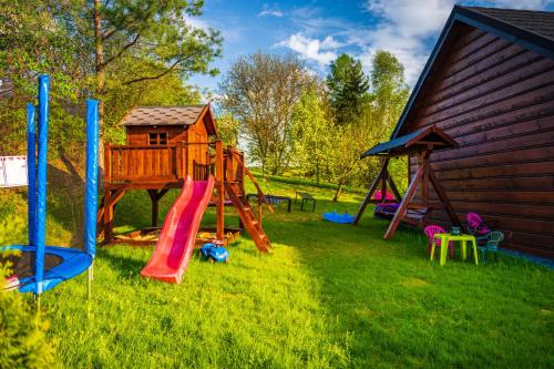 a playground with a slide and a play house at Apartamenty na Jurze in Siamoszyce