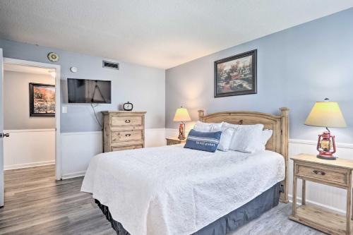 a bedroom with a bed with a white bedspread and a television at Gatlinburg Condo with Balcony Less Than 4 Mi to Downtown! in Gatlinburg