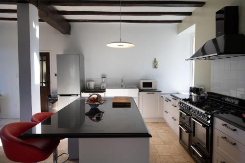 een keuken met een zwart aanrecht in een kamer bij La Petite Ecole in Treignac