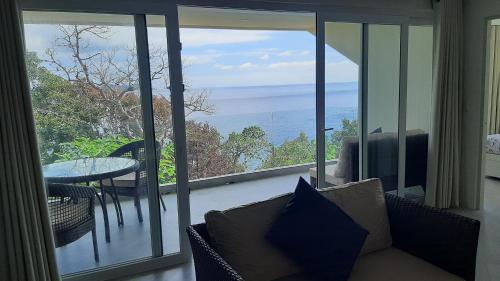 a living room with a couch and a view of the ocean at Amal Villa - Luxury 2 Bed, 2 Bath Apartment with Panoramic Ocean Views, Peaceful, Private Beach in San Jose