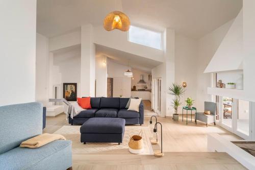 a large living room with a blue couch and a living room at Villa Ester - A Sardinian Paradise in Costa Paradiso