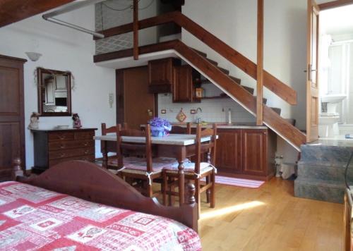 uma cozinha com uma mesa de jantar e uma escada em Ao.centrum em Aosta