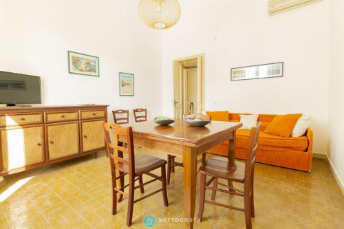 ein Wohnzimmer mit Tisch und Stühlen und einer Couch in der Unterkunft PEARL OF THE SEA - SAN FOCA in San Foca