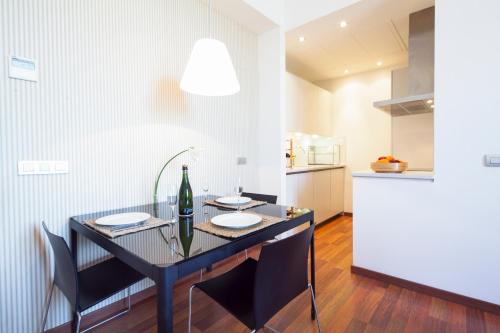 a kitchen with a table and chairs and a refrigerator at Inside Barcelona Apartments Mercat in Barcelona