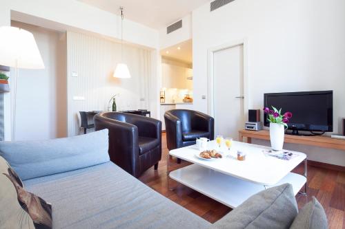 a living room filled with furniture and a tv at Inside Barcelona Apartments Mercat in Barcelona