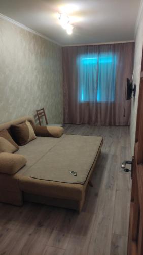 a bed in a room with a couch and a window at Apartment near the Trinity Church on Dovzhenko Street,102 in Chernihiv